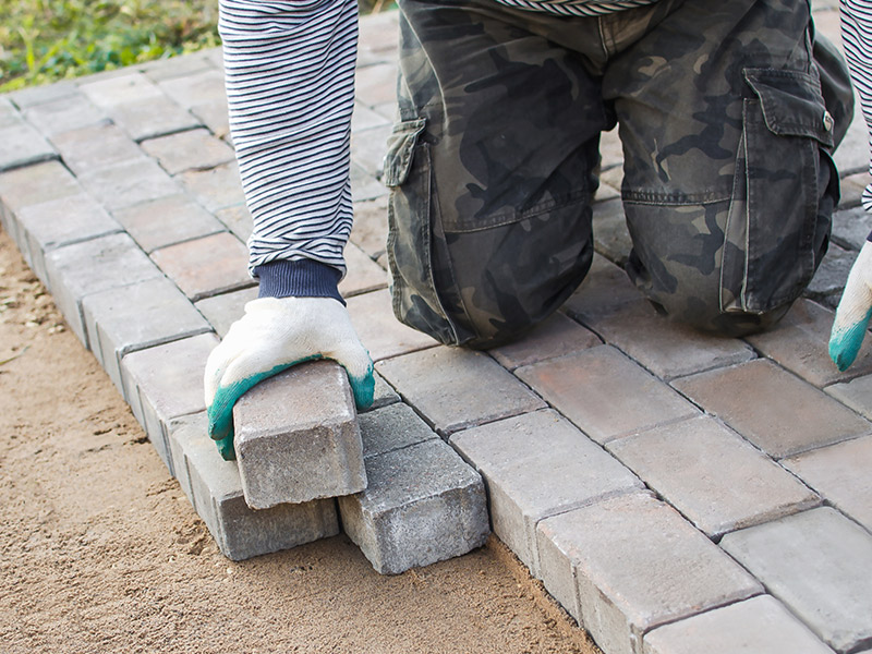 contractor installing concrete bricks to build a concrete sidewalk at property blue ridge mo