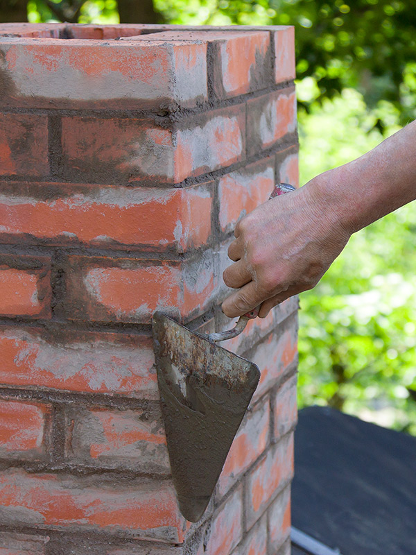 contractor with trowel building a masonry chimney blue ridge mo